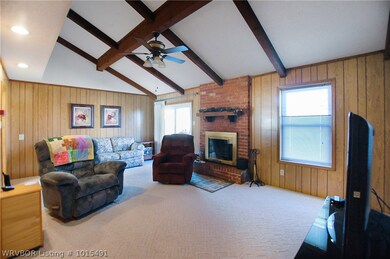 Exposed beams and gas starter fireplace. Window is