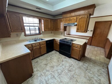 Kitchen with a textured ceiling, black appliances,