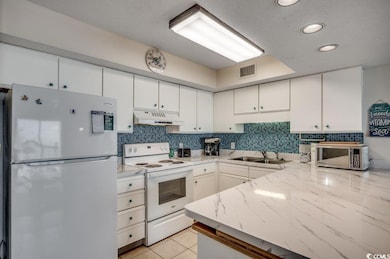 Kitchen with sink, light tile patterned floors, ba