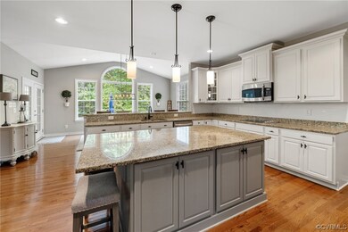 Kitchen with white cabinets, vaulted ceiling, gran