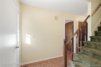 Stairway featuring brick patterned floors and baseboards