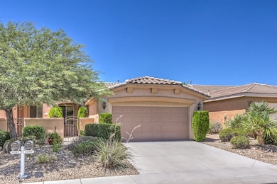 Mediterranean / spanish-style house with stucco siding, an attached garage, driveway, a tile roof, and a gate