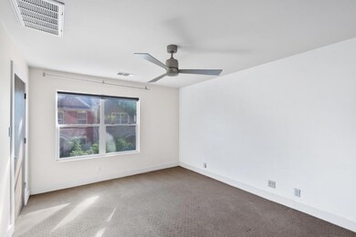 Carpeted spare room with baseboards and a ceiling fan