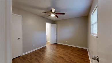 Unfurnished bedroom with dark wood-type flooring and ceiling fan