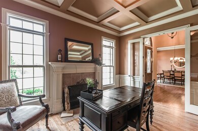 Graced with 8 ft. French Doors, the 15x13 office is on the main level. Exquisite Coffered Ceiling, Rich Hardwoods, Gas Fireplace, Two Windows with Transoms flanking the fireplace offers exceptional views of the front yard. 