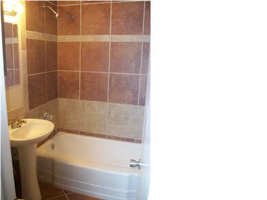 Updated bathroom with tiled tub surround and floor
