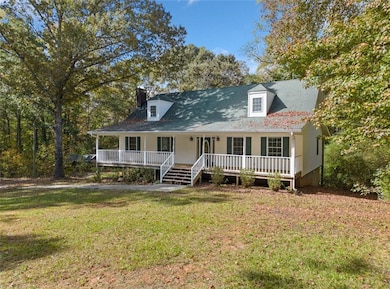 View of front of house with a porch and a front ya