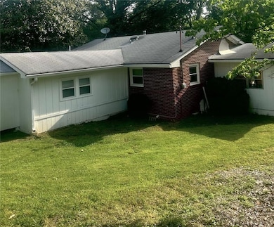 Back of house featuring a yard and a shingled roof