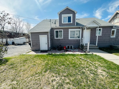 View of front of home featuring a patio, a front yard, and a shingled roof