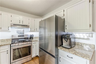 Kitchen featuring stainless steel appliances, unde
