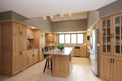 Gourmet kitchen with center island, stainless steel appliances and granite countertops.