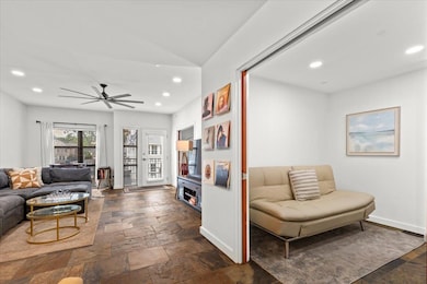 Living area with baseboards, recessed lighting, vaulted ceiling, ceiling fan, and stone tile floors