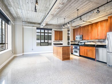 Kitchen with light speckled floor, dark counterto