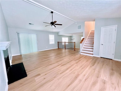 Unfurnished living room featuring ceiling fan with