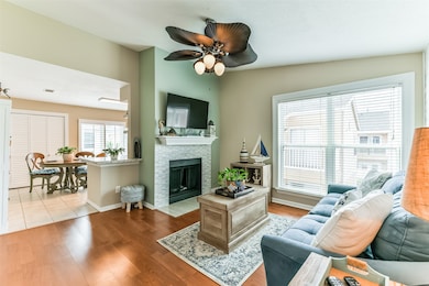 Living room is spacious with large windows and a woodburning fireplace.