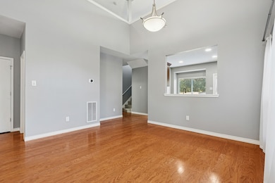 Dining area with hardwood floors, vaulted ceiling, and open to the kitchen.