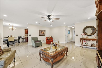 Living area featuring recessed lighting, a chandelier, ceiling fan, light tile floors, and ornamental molding