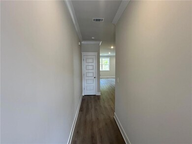 Hallway featuring crown molding, dark wood-style flooring, and baseboards