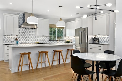 Kitchen featuring wall chimney range hood, a cent