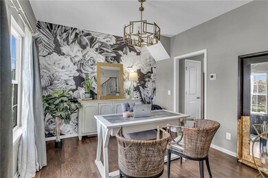 Dining room with dark hardwood / wood-style flooring and an inviting chandelier