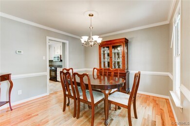 Formal Dining Room with Hardwood Floors, Chair Rail, Chandelier, Crown Molding.
