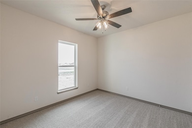 Carpeted spare room featuring baseboards