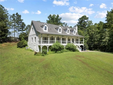 New england style home with ceiling fan, a front yard, covered porch, and a chimney