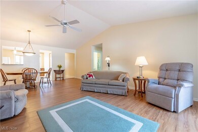 Living area featuring wood finished floors, vaulted ceiling, and ceiling fan