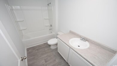Full bathroom featuring shower / bathing tub combination, vanity, toilet, and hardwood / wood-style floors