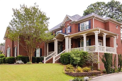View of front of property featuring brick siding, covered porch, a front yard, and stairs