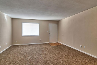 Carpeted spare room featuring a textured ceiling