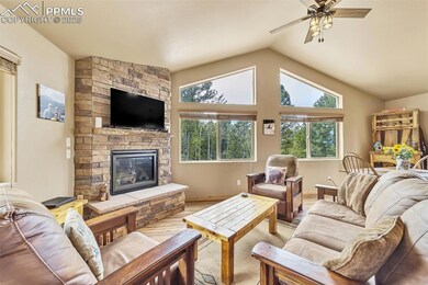 Living room with vaulted ceiling, a fireplace, lig