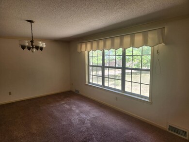 Living room with carpet floors, a textured ceiling