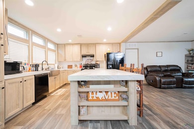 Kitchen with light brown cabinetry, under cabinet 