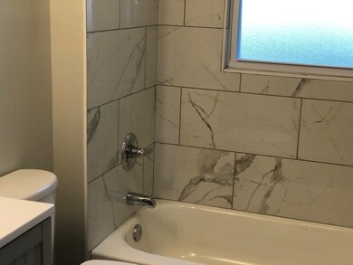 Full bathroom featuring vanity, toilet, and tiled 