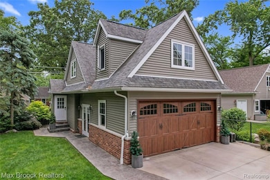 View of front facade with concrete driveway, a garage, and a shingled roof