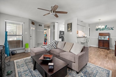 Living room featuring a ceiling fan, light wood-t