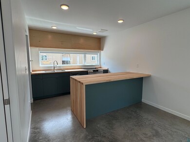 Kitchen featuring butcher block counters, a peninsula, stainless steel range with electric stovetop, and recessed lighting