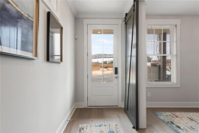 Doorway to outside with light wood-style flooring, a wealth of natural light, and a barn door