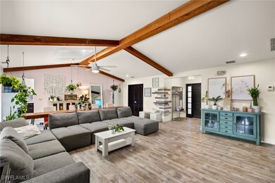 Living room featuring ceiling fan, light hardwood