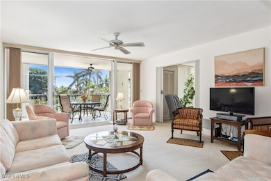Living room featuring light carpet, a wall of wind