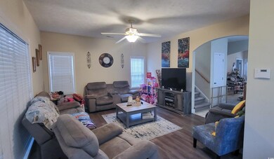 Living room with dark wood-type flooring and ceili