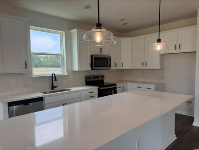Kitchen featuring stainless steel appliances, a sink, white cabinets, and tasteful backsplash