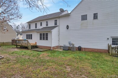 Back of house featuring a yard, a wooden deck, and