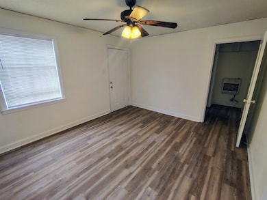 Unfurnished room with dark wood-type flooring, hea