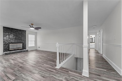 Unfurnished living room featuring a ceiling fan, b
