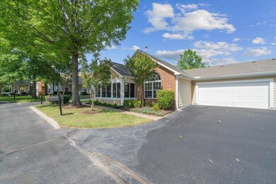 View of front of house with brick siding, asphalt driveway, and a garage