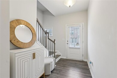 Doorway featuring dark wood finished floors, baseb