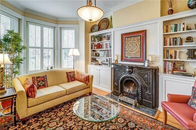 Living room has remote gas coal fireplace, bay window, built ins and plantation shutters