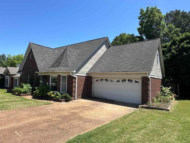 View of front of house featuring brick siding, an attached garage, a front yard, and concrete driveway